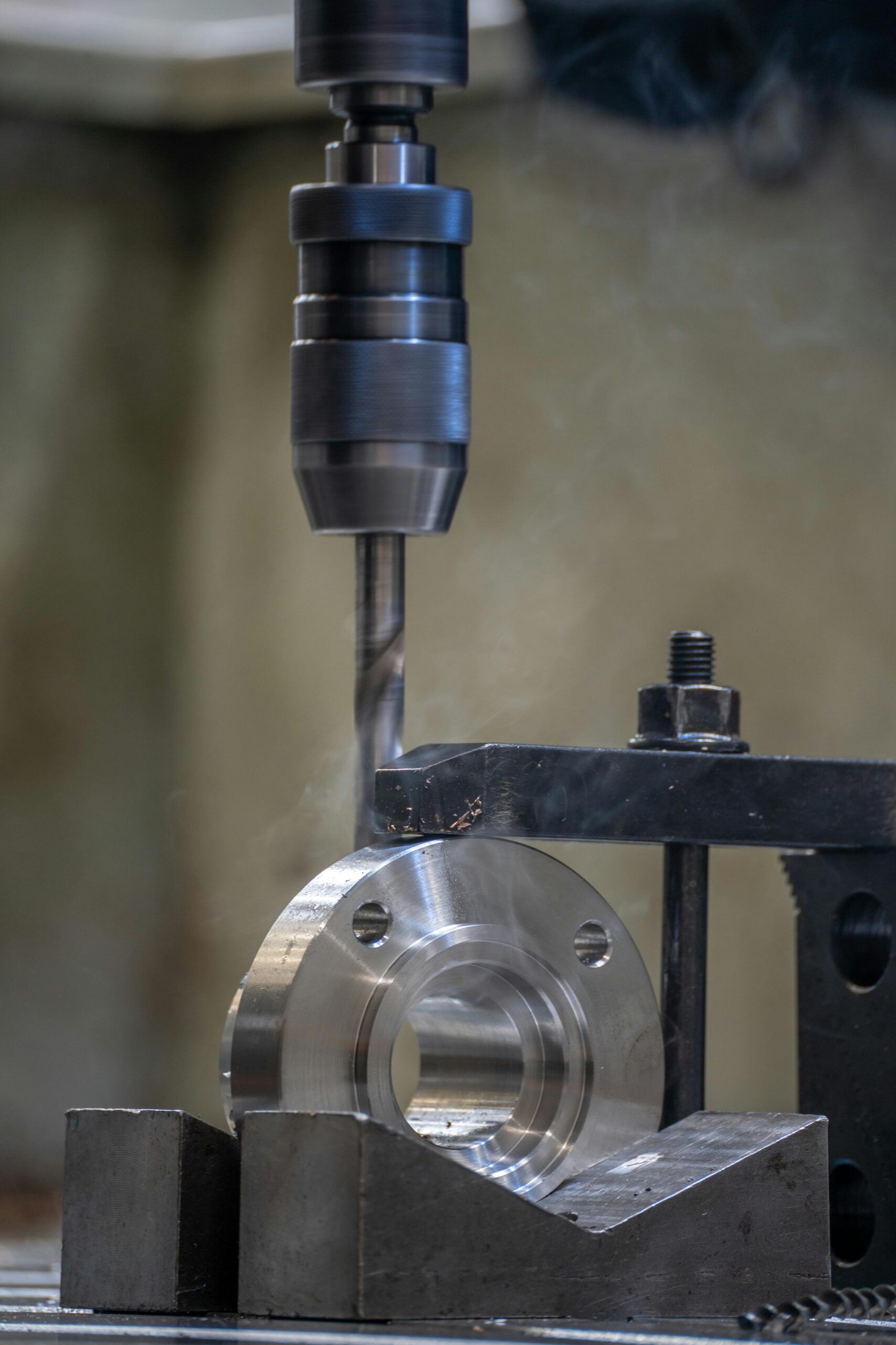 Close-up view of a metal drilling process in an industrial workshop setting.